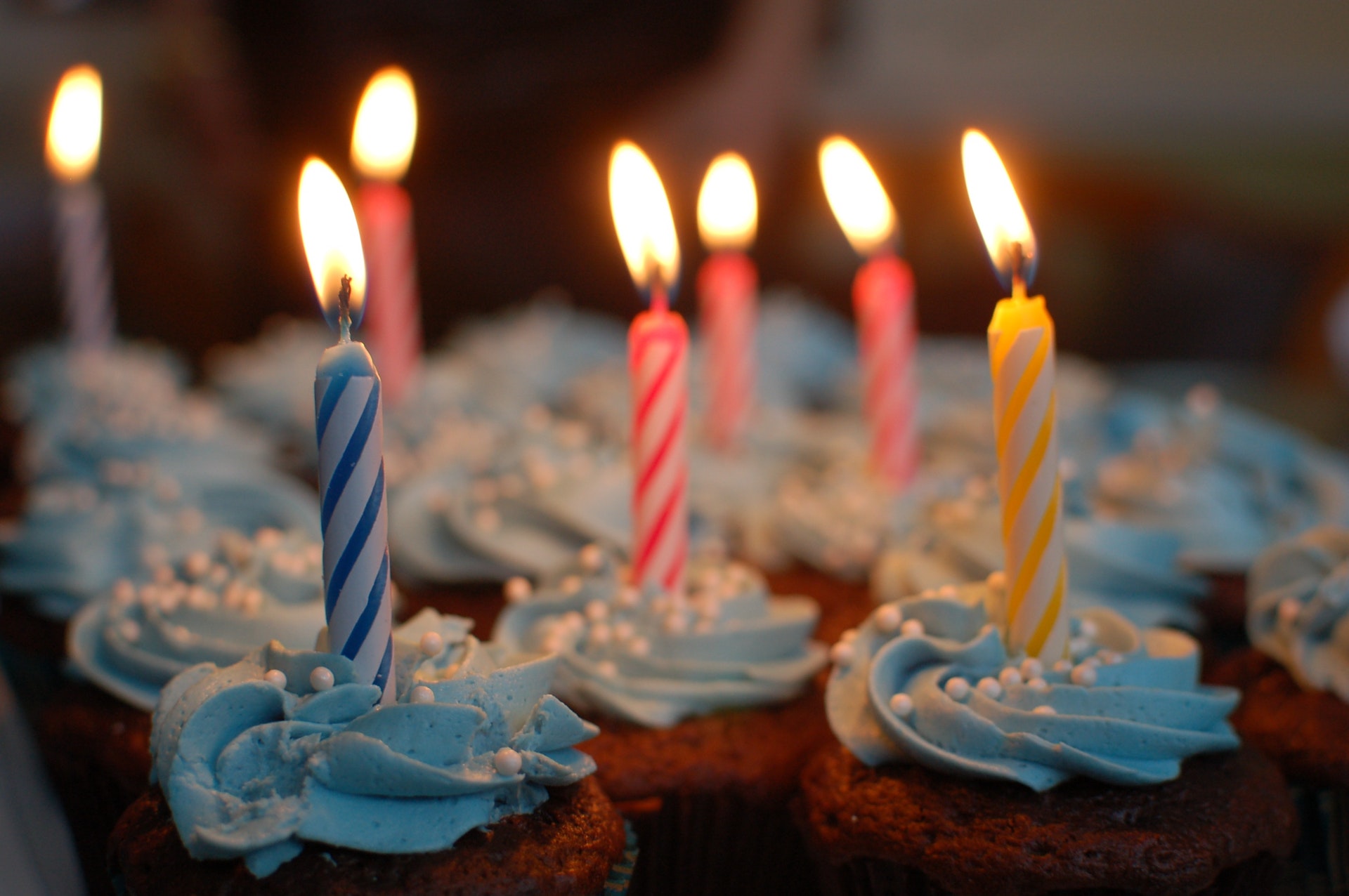 Lighted candles on cupcakes with blue frosting
